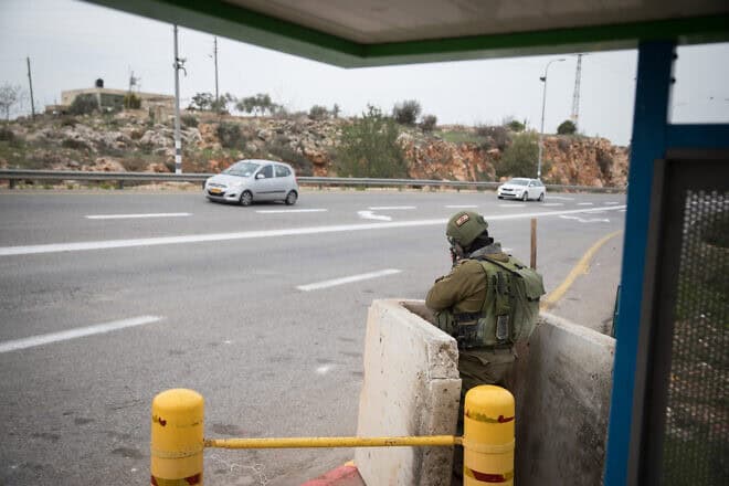 Israeli soldiers guard a bus stop on Route 60 near the entrance to the Israeli community of Ofra in Samaria, Dec. 16, 2018. Photo by Hadas Parush/Flash90.