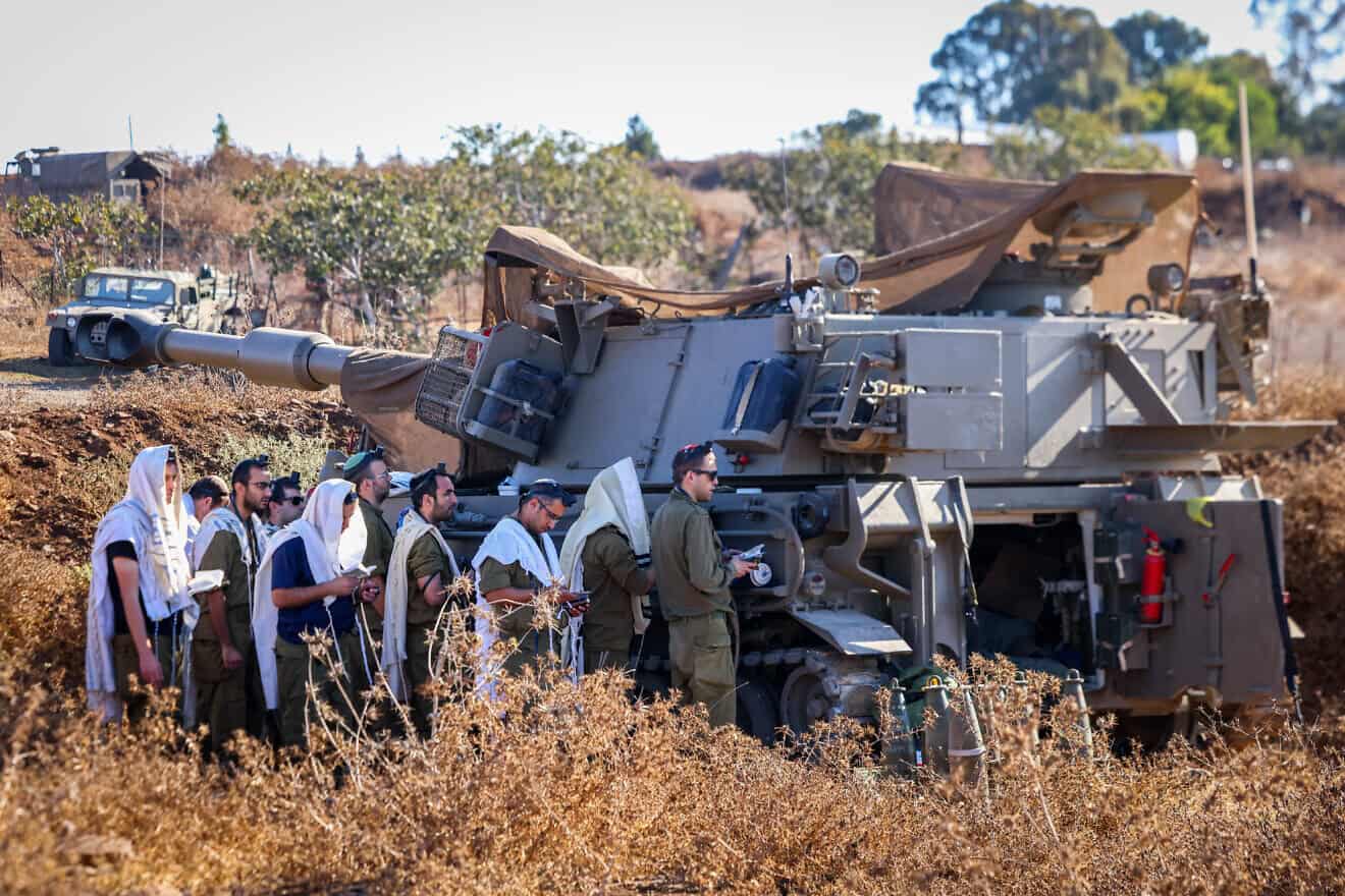 Israeli soldiers pray next to their artillery units near the Israeli border with Lebanon, northern Israel, Sept. 29, 2024. Photo by David Cohen/Flash90.