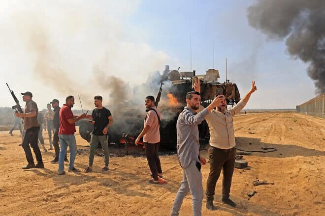 Palestinians take control of an Israeli Merkava battle tank after crossing the border fence with Israel from Khan Yunis in the southern Gaza Strip on Oct. 7, 2023. Photo by Said Khatib/AFP via Getty Images.