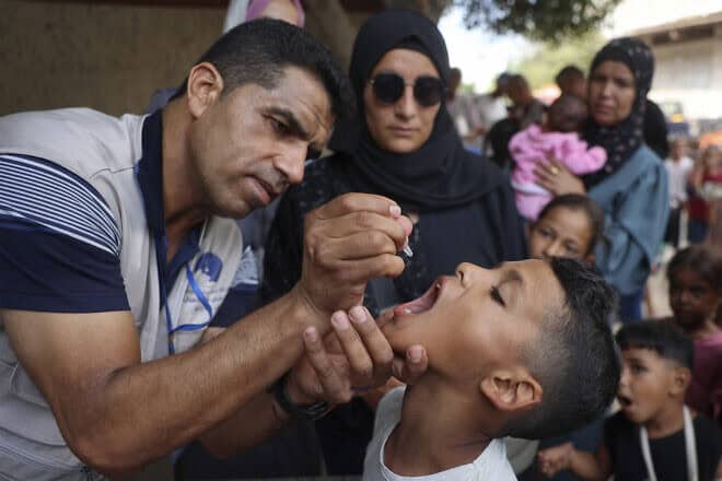 A health worker administers the polio vaccine to a Palestinian child in the central Gaza Strip, Sept. 1, 2024. Photo by Eyad Baba/AFP via Getty Images.
