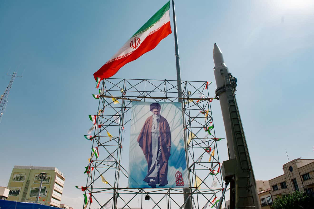 A banner depicting Iranian Supreme Leader Ayatollah Ali Khamenei is placed next to a ballistic missile in Baharestan Square in Tehran, Sept. 26, 2024. Photo by Hossein Beris/Middle East Images/AFP via Getty Images.