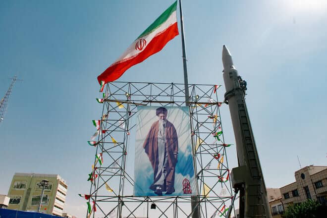 A banner depicting Iranian Supreme Leader Ayatollah Ali Khamenei is placed next to a ballistic missile in Baharestan Square in Tehran, Sept. 26, 2024. Photo by Hossein Beris/Middle East Images/AFP via Getty Images.