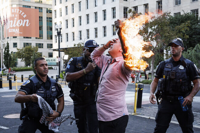Police help a man who tried to set himself on fire during an anti-Israel demonstration, marking the one-year anniversary of Hamas's Oct. 7, 2023, terror attack on southern Israel, near the White House in Washington, D.C. on Oct. 5, 2024. Photo by Ting Shen/AFP via Getty Images.