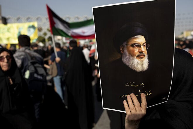 An Iranian demonstrator carries a poster of slain Hezbollah leader Hassan Nasrallah in a rally in Tehran commemorating him, Oct. 2, 2024. Photo by Majid Saeedi/Getty Images.