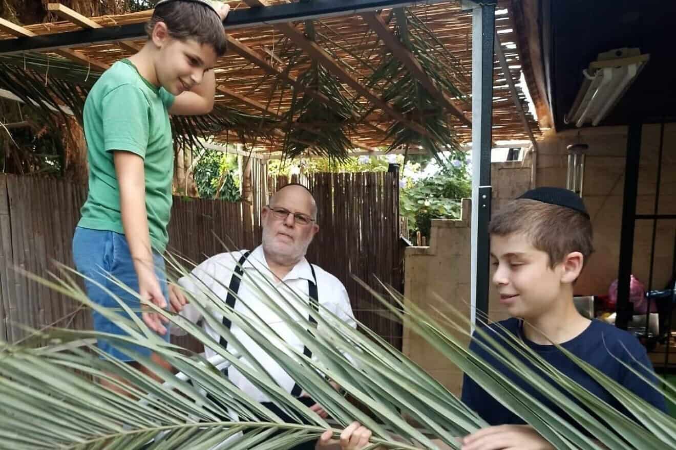 Gershon Markowitz builds a sukkah in Jerusalem with grandsons David (left) and Binyamin Tub. Credit: Courtesy.