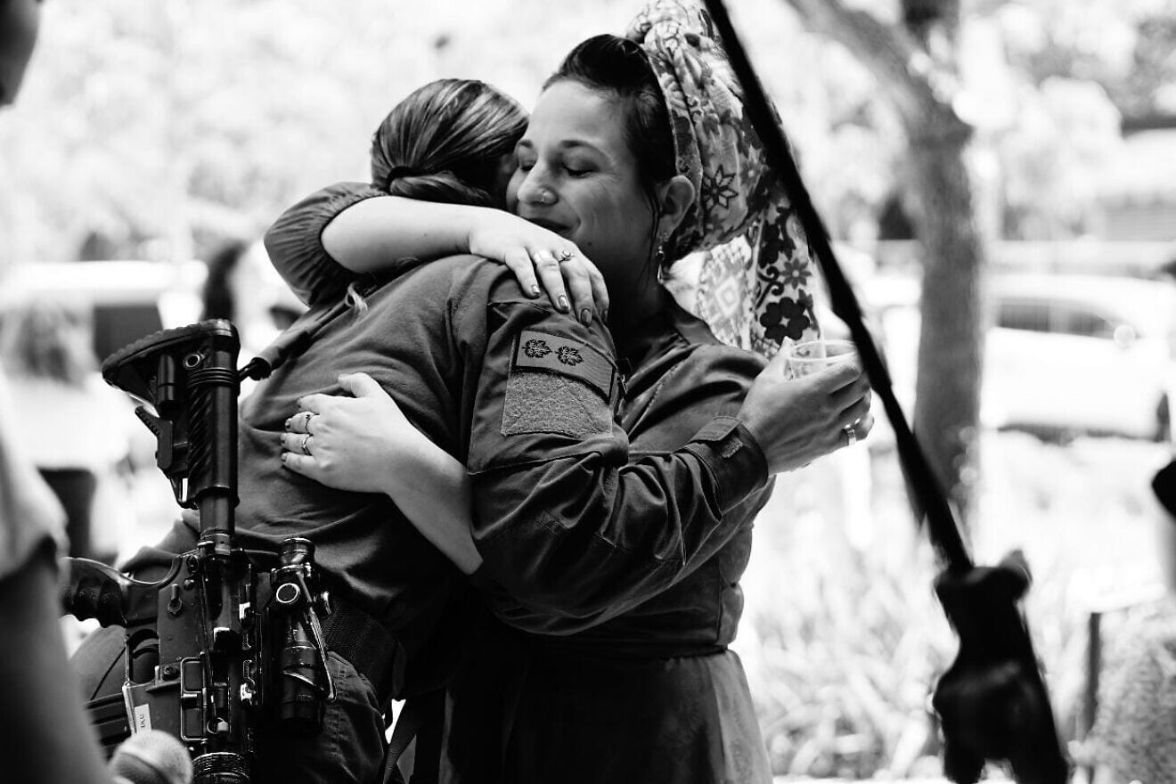 Hadassa Ben Ari (right), the head of "The Heroes of October 7th: Heroic Stories for Children" project, embraces a hero. Credit: Courtesy.