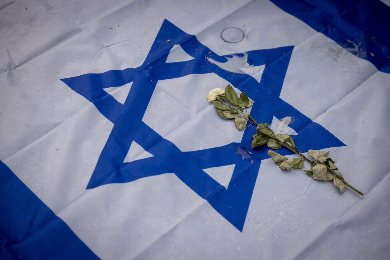 Flags, candles, flowers on Dizengoff Square in Tel Aviv in memory of the 1,200 people slaughtered when Hamas infiltrated the border with southern Israel on Oct. 7, and took as many as 250 hostages back into the Gaza Strip, where 101 still remain, Oct. 29, 2023. Photo by Chaim Goldberg/Flash90.