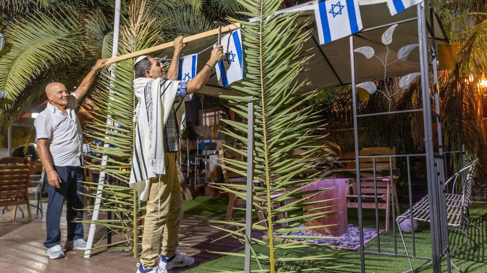 Israelis build and decorate a sukkah in moshav Yashresh in central Israel at the end of Yom Kippur for the upcoming Jewish holiday of Sukkot, Sept. 25, 2023. Photo by Yossi Aloni/Flash90.