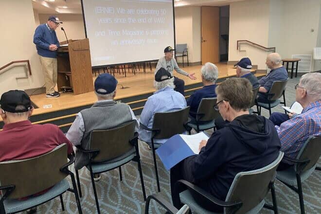 World War II veteran Alfred Benjamin (seated on stage) directs the men playing roles in his play based on time in the U.S. Air Force, titled “In the Dark of the Night,” November 2024. Credit: Hebrew SeniorLife.
