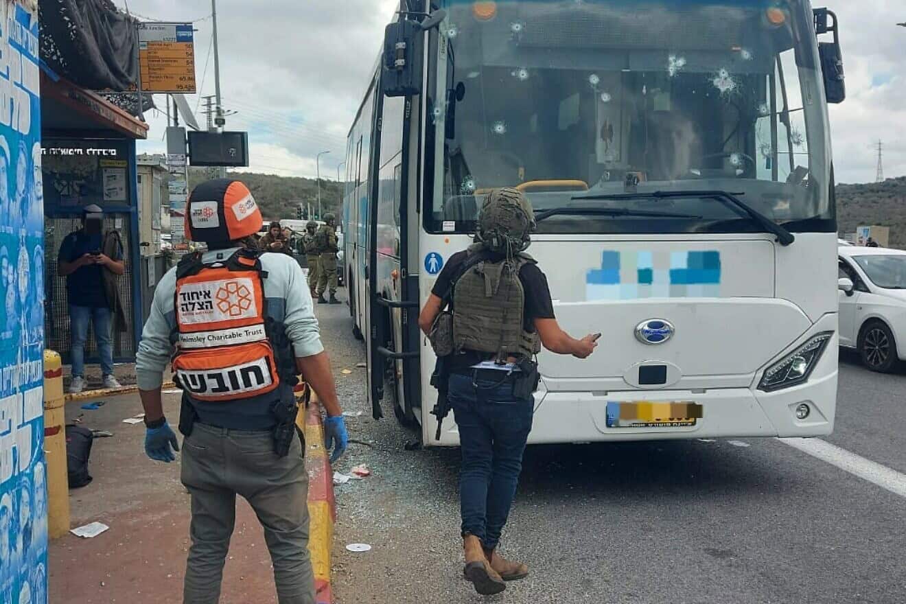 A United Hatzalah medic and an off-duty soldier examine a bus that was attacked near Ariel in Samaria on Nov. 29, 2024. Credit: United Hatzalah.