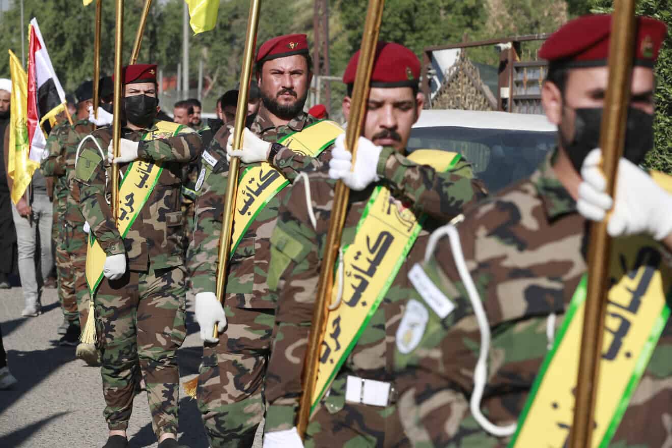 Flags of Iraq and paramilitary groups, including al-Nujaba and Kataib Hezbollah, are displayed during a funeral in Baghdad for five militants killed a day earlier in a U.S. strike in northern Iraq, on Dec. 4, 2023. Photo by Ahmad al-Rubaye/ AFP via Getty Images.