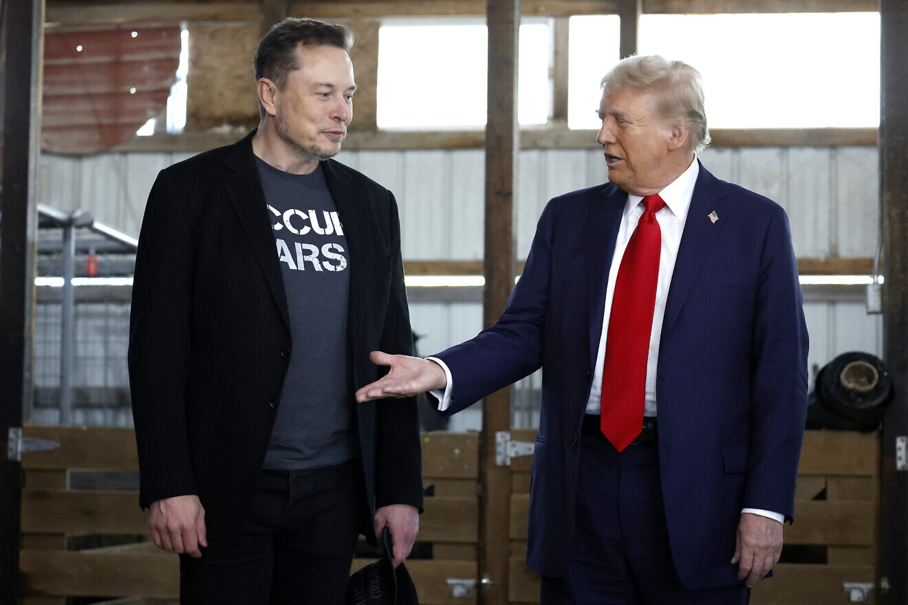 Republican presidential nominee, former President Donald Trump offers his hand to Elon Musk back stage during a campaign rally at the Butler Farm Show grounds on Oct. 5, 2024 in Butler, Pa. Photo by Anna Moneymaker/Getty Images.