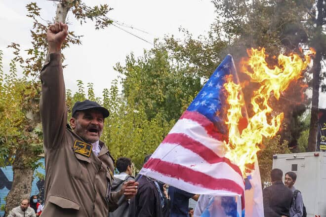 A man holds a burning American flag during a rally outside the former U.S. embassy in Tehran as Iranians mark the 45th anniversary of the start of the Iran hostage crisis, on Nov. 3, 2024. Photo by Atta Kenare/AFP via Getty Images.