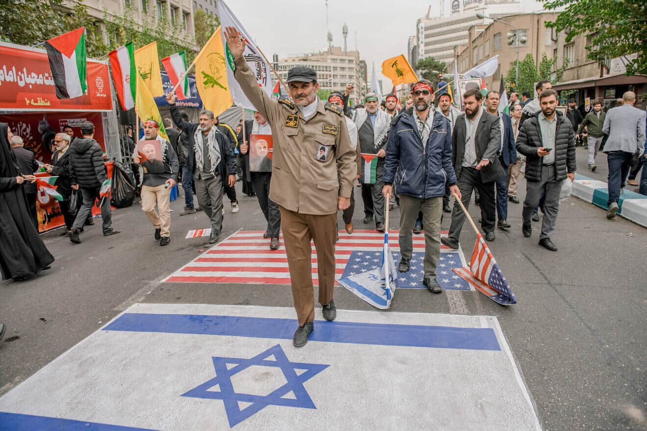 Iranians step on U.S. and Israeli flags in an area decorated with Hezbollah and PLO flags during a rally outside the former U.S. embassy in Tehran on Nov. 3, 2024. Photo by Hossein Beris/Middle East Images/AFP via Getty Images.