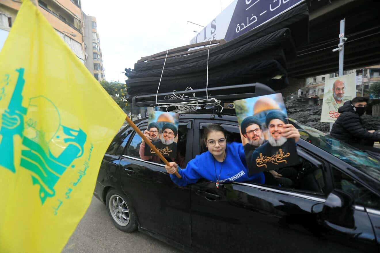 A Lebanese woman holds up portraits of Hezbollah's slain leaders Hassan Nasrallah and Hashem Safieddine as supporters of the terrorist group parade in Beirut's southern suburbs after a ceasefire is put in place between Israel and Lebanon, Nov. 27, 2024. Photo by AFP via Getty Images.