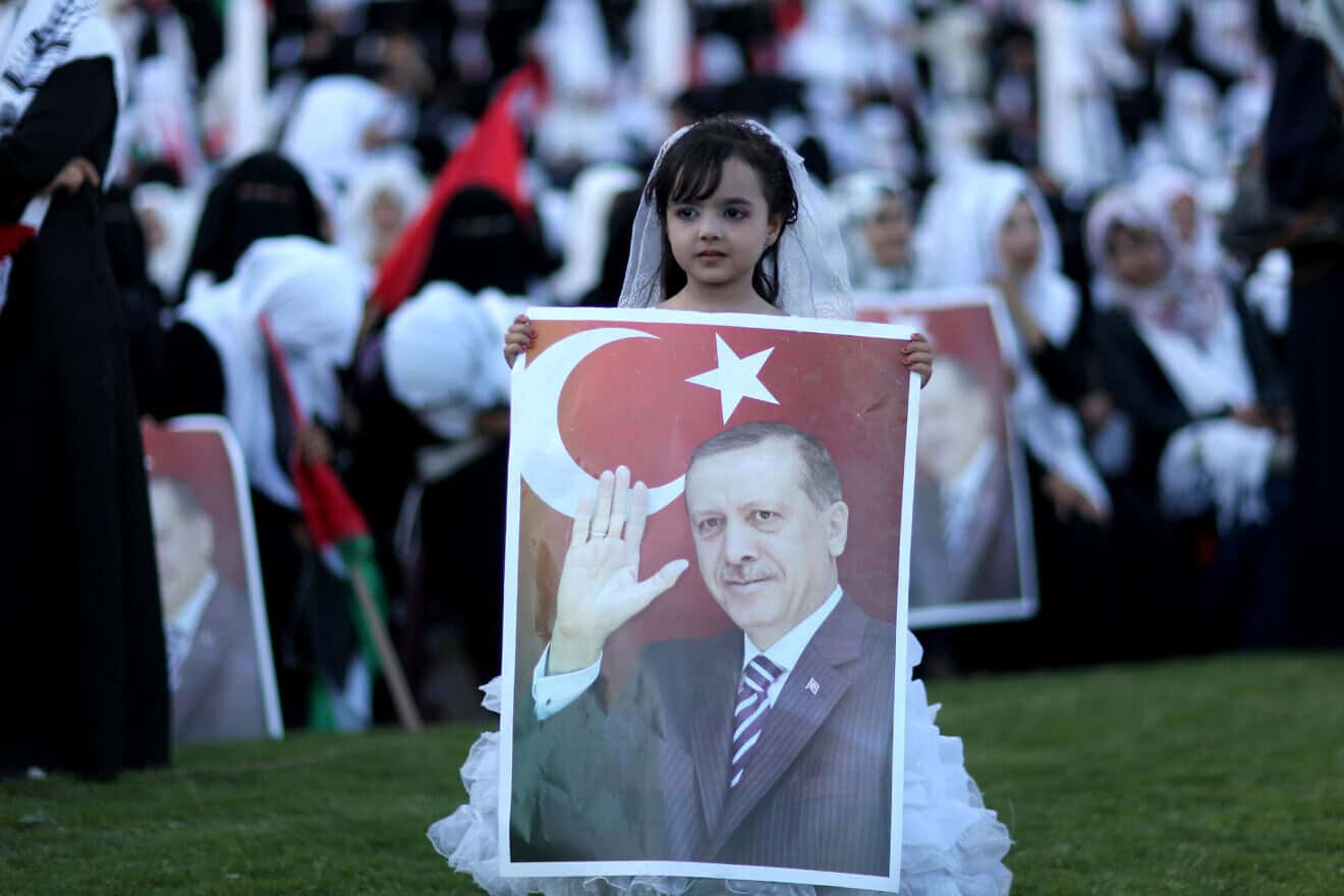 A Palestinian girl holds a picture of Turkish President Recep Tayyip Erdoğan during a mass wedding ceremony in Gaza City on May 31, 2015. Nearly 4,000 Palestinian couples were married in a ceremony funded by the Turkish government. Photo by Aaed Tayeh/Flash90.