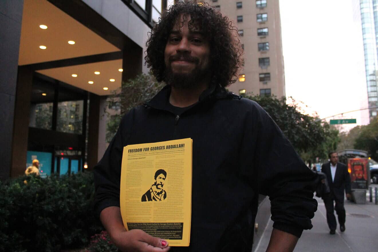 A demonstrator holds a flier bearing the portrait of George Ibrahim Abdallah outside the mission of France to the United Nations in New York on Oct. 16, 2017. Photo by Joe Catron/Flickr.