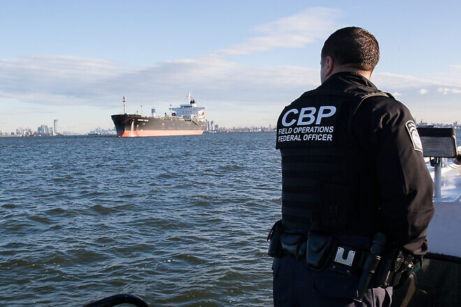 A U.S. Customs and Border Protection officer looks out at the fuel tanker upon which he and another officer are about to board and do a crew immigration inspection, Port of New York/Newark, Nov. 3, 2012. Credit: Josh Denmark/U.S. Customs and Border Protection.