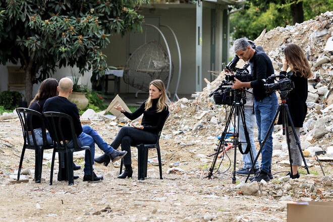 "Channel 12" journalist Adva Dadon backdropped by destruction from the massacre on Oct. 7, 2023, at Kibbutz Be'eri, Jan. 3, 2024. Photo by Moshe Shai/Flash90.