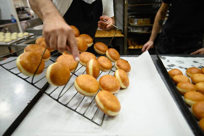 Workers prepare "sufganiyot" (doughnuts) at the Alon Confectionery in northern Israel, ahead of the Jewish holiday of Chanukah, on Dec. 14, 2022. Photo by Ayal Margolin/Flash90.