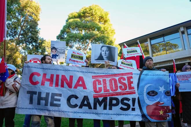 Uyghur and counter-China demonstrators hold a banner and placards as they await the arrival of China's Premier Li Qiang at the Adelaide Zoo in south Australia on June 16, 2024. Photo by Asanka Ratnayake/POOL/AFP via Getty Images.