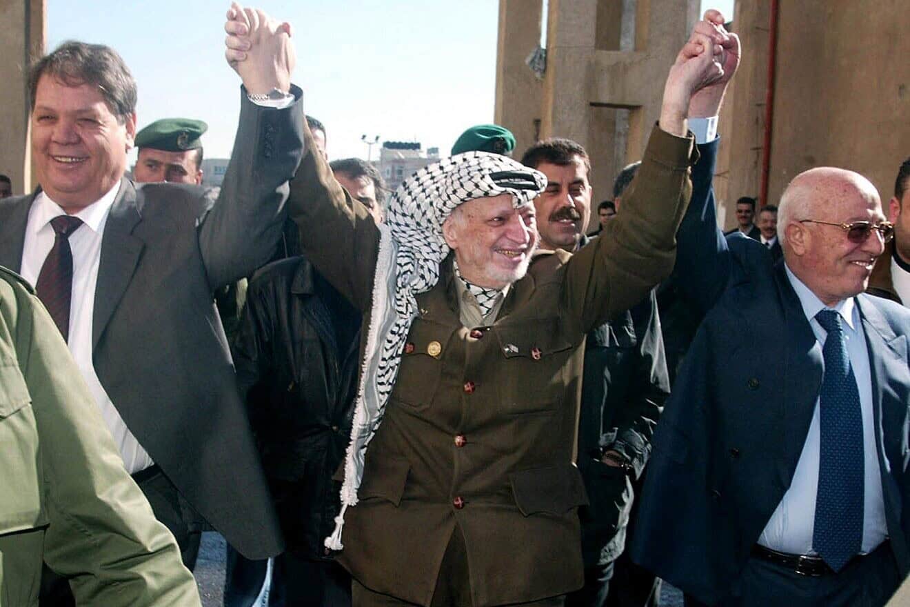 At left: Rawhi Fattouh, then-agricultural minister, in Ramallah with PLO leader Yasser Arafat and Ahmed Qorei,  Palestinian politician who served as the second prime minister of the Palestinian National Authority, on Jan. 6, 2004. Photo by Jamal Aruri/AFP Photo via Getty Images.