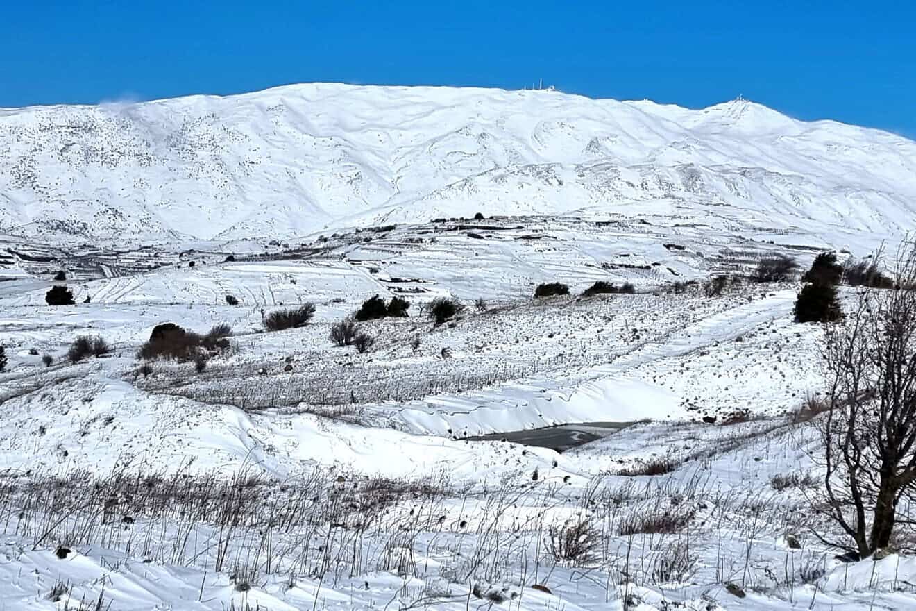 A panoramic view of the snow-covered Mount Hermon and the surrounding orchards and vineyards near Kibbutz El Rom in Israel's Golan Heights, on Jan. 20, 2022. Photo by David Silverman/Getty Images.