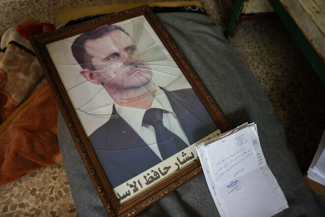 A portrait of Syrian President Bashar Assad with its frame broken, in a Syrian regime's political security branch facility on the outskirts of the central city of Hama, following the capture of the area by anti-government forces, on Dec. 7, 2024. Photo by Omar Haj Kadour/AFP via Getty Images.