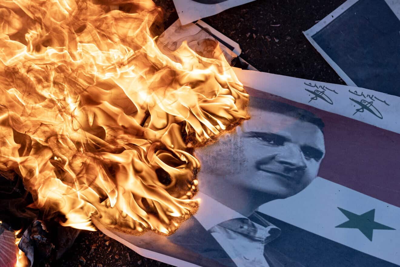 Syrians burned Assad's flags and gathered in a central square in Damascus to celebrate their liberation from the Assad regime in Damascus Square on Dec. 13, 2024 in Damascus, Syria. Photo by Ugur Yildirim/dia images via Getty Images.