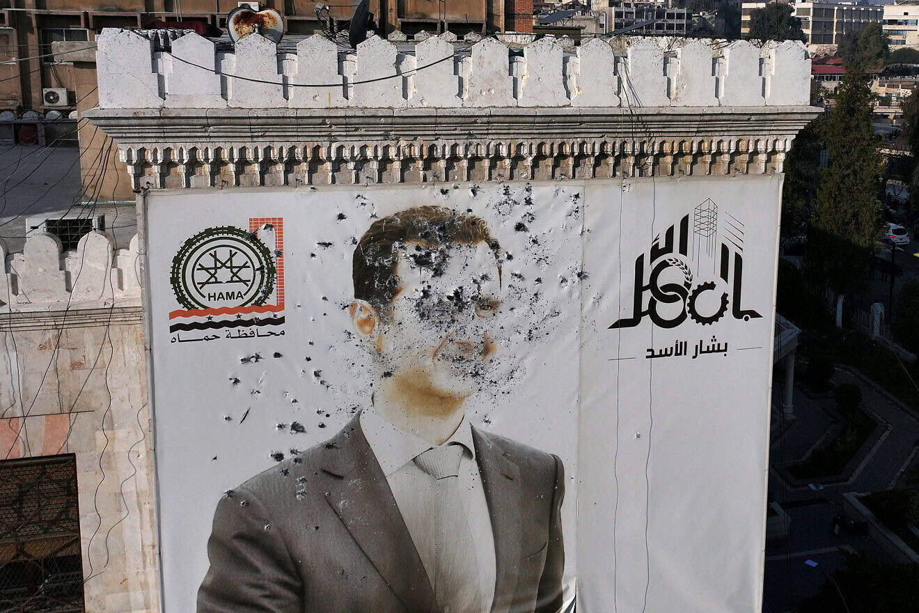 A bullet-riddled portrait of Syrian President Bashar Assad adorning Hama's municipality building after it was defaced following the capture of the city by anti government fighters on Dec. 6, 2024. Photo by Omar Haj Kadour/AFP via Getty Images.