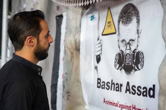 A poster depicts Syrian President Bashar Assad in a gas mask during an event in the rebel-held northern city of Afrin, marking the 10-year anniversary of chemical attacks that killed more than 1,400 people in Ghouta, near the capital, on Aug. 20, 2023. Photo by Rami Al Sayed/AFP via Getty Images.