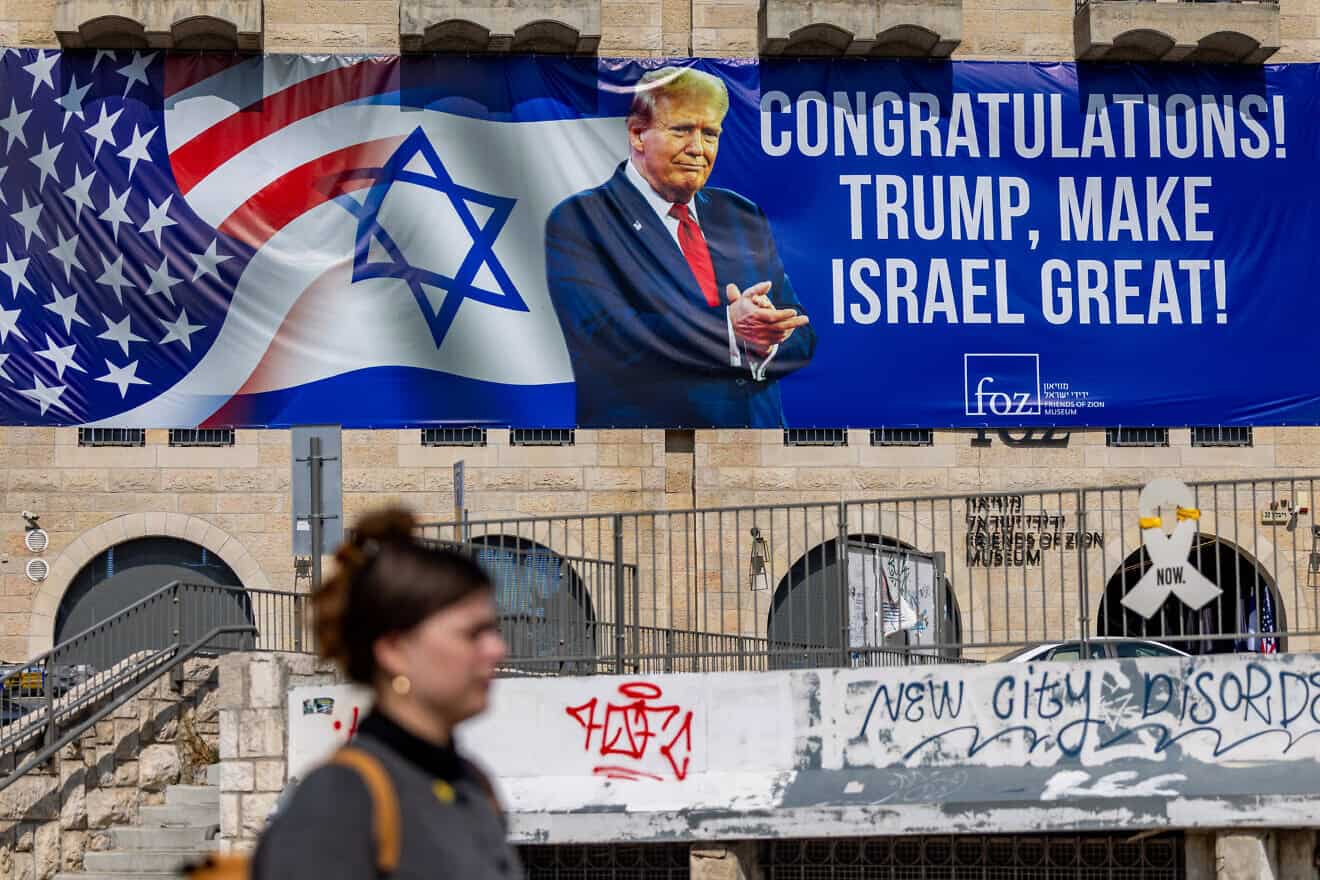 Pepole walk in central Jerusalem next to a sign congratulating Donald Trump for his victory in the U.S. presidential election, Nov. 7, 2024. Photo by Yonatan Sindel/Flash90.