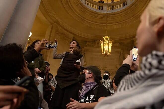 Lara Kiswani (center), executive director of the Arab Resource and Organizing Center, speaks in the San Francisco City Hall rotunda on Jan. 9, 2024, during efforts to pass a Gaza cease-fire resolution. Photo by Aaron Levy-Wolins.
