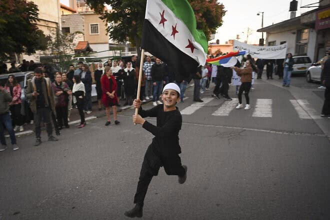 A boy in Majdal Shams, Israel, celebrates with a “Free Syria” flag after rebels take over the regime of Bashar Assad in Syria, Dec. 9, 2024. Photo by Michael Giladi/Flash90.