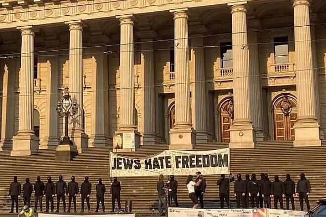 Masked neo-Nazi protesters display a giant banner reading "Jews hate freedom" on the steps of Victoria's Parliament in Melbourne, Australia, Dec. 20, 2024. Credit: David Southwick MP