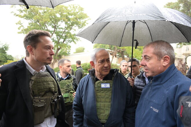 Elon Musk and Israeli Prime Minister Benjamin Netanyahu speak with Sha’ar HaNegev Regional Council acting head Yossi Keren (right) in Kibbutz Kfar Aza, Nov. 27, 2023. Credit: Amos Ben-Gershom/GPO.