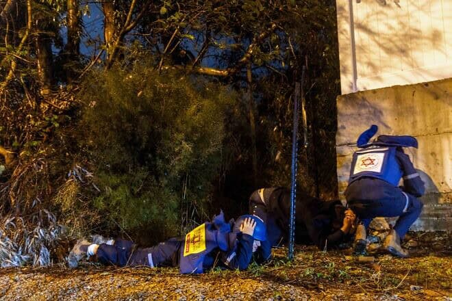 People take cover as siren warns of incoming missile fired from Yemen, near Rehovot, Dec. 30, 2024. Photo by Yossi Aloni/Flash90.