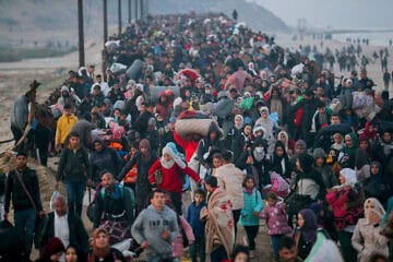 Gazans walk north on the al-Rashid Road coastal route to cross the Netzarim Corridor on Jan. 27, 2025. 