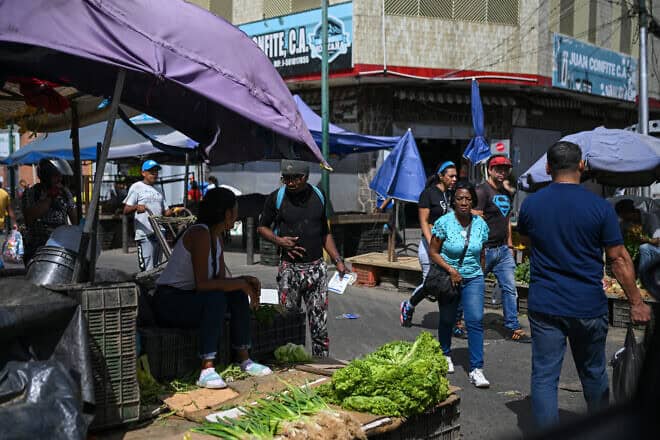 People walk through the street market at the Perez Bonalde square in the Catia neighborhood in Caracas on Jan. 6, 2025. Photo by Federico Parra/AFP via Getty Images.