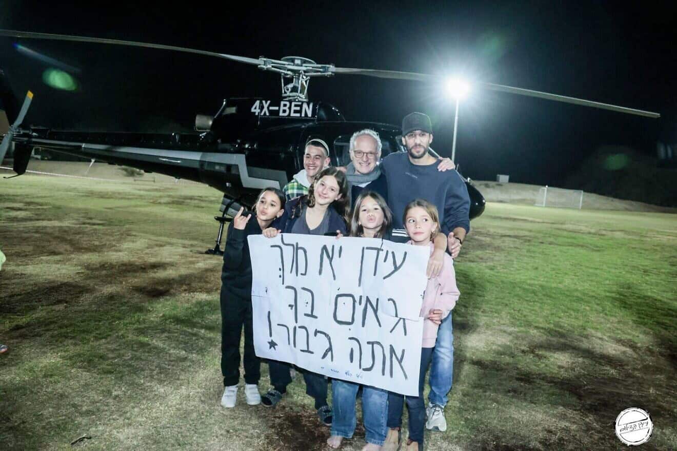 The children's sign hails "Fauda" star Idan Amedi (right) as a king and a hero. He and OneFamily Chairman Marc Belzberg pose with children who have lost a parent or sibling to terrorism or war, at Kibbutz Revivim in the Negev, Dec. 30, 2024. Credit: OneFamily.