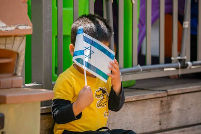 A child holds an Israeli flag ahead of Israel's 73rd Independence Day at a kindergarten in Moshav Yashresh, April 13, 2021. Photo by Yossi Aloni/Flash90.