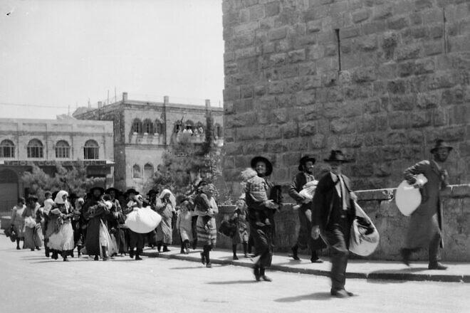 Following riots by Arabs in British Mandatory Palestine, Jews flee the Old City of Jerusalem with their belongings stuffed in bags, August 1929. Credit: U.S. Library of Congress via Wikimedia Commons.
