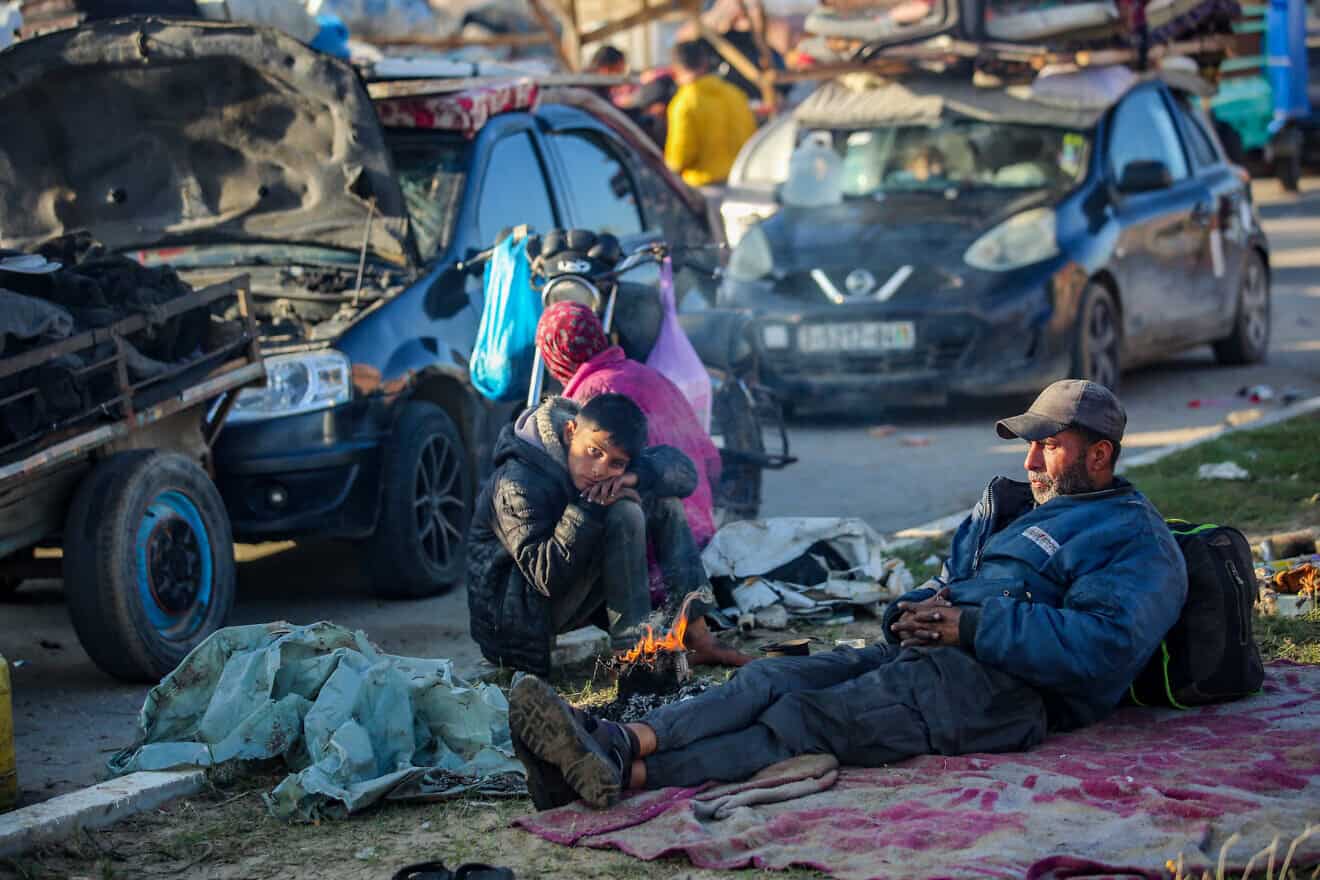 Palestinians wait on Salah al-Din Road, the main highway of the Gaza Strip, not far from the Netzarim Corridor that separates the north of the Gaza Strip from the south, Jan. 26, 2025. Photo by Ali Hassan/Flash90.