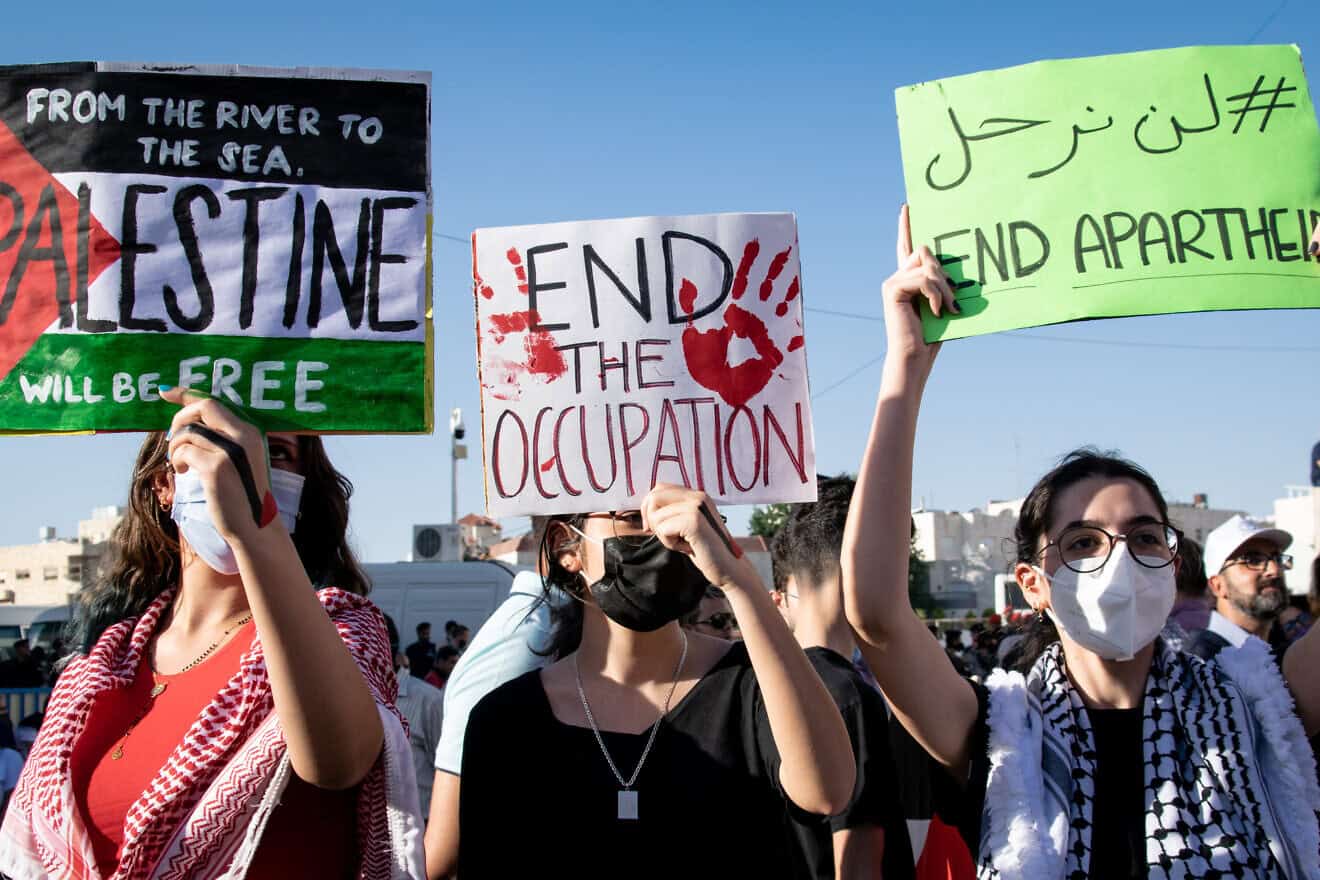 Pro-Palestinian demonstrators hold signs anti-Zionist signs during Israel's 11-day conflict against Hamas in Gaza, the IDF's “Operation Guardian of the Walls,” in May 2021. Credit: Raya Sharbain via Wikimedia Commons.