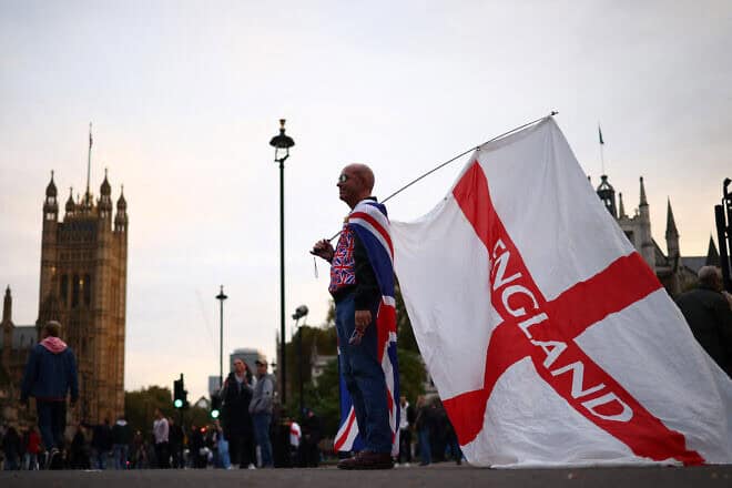 A British supporter of anti-Muslim agitator Tommy Robinson stands in Parliament Square after a “Uniting the Kingdom” march through central London on Oct. 26, 2024. Photo by Henry Nicholls/AFP via Getty Images)