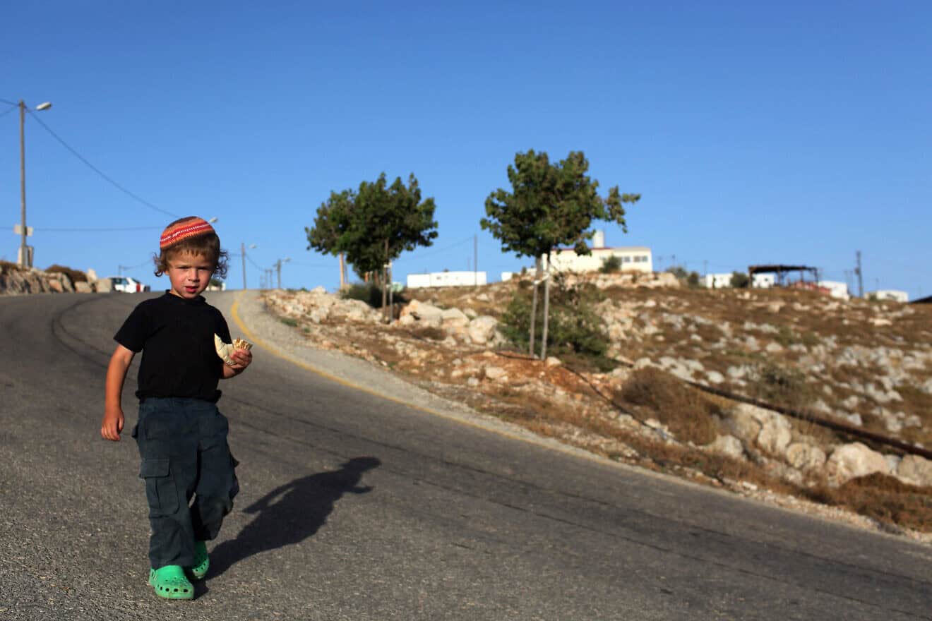 An Israeli child poses for the camera as he eats pita bread at the Ahiya outpost in the Binyamin region of southern Samaria, June 6, 2010. Photo by Kobi Gideon/Flash90.