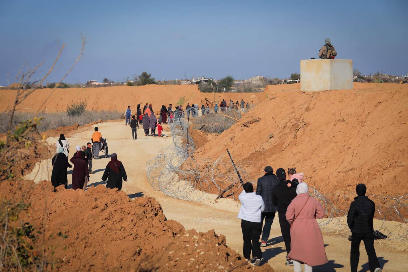 Gazans walk alongside an Israeli army post in northern Gaza, Jan. 28, 2025. Photo by Ali Hassan/Flash90.