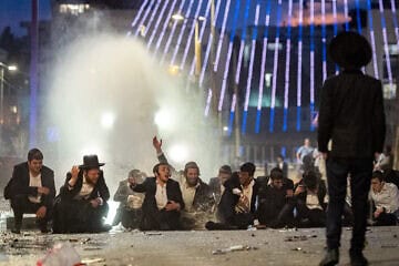 Haredi Jews protest and clash with police during a protest against the drafting of Haredi Jews to the Israeli army, outside a conference on the issue in Jerusalem on Jan. 28, 2025. Photo by Chaim Goldberg/Flash90.