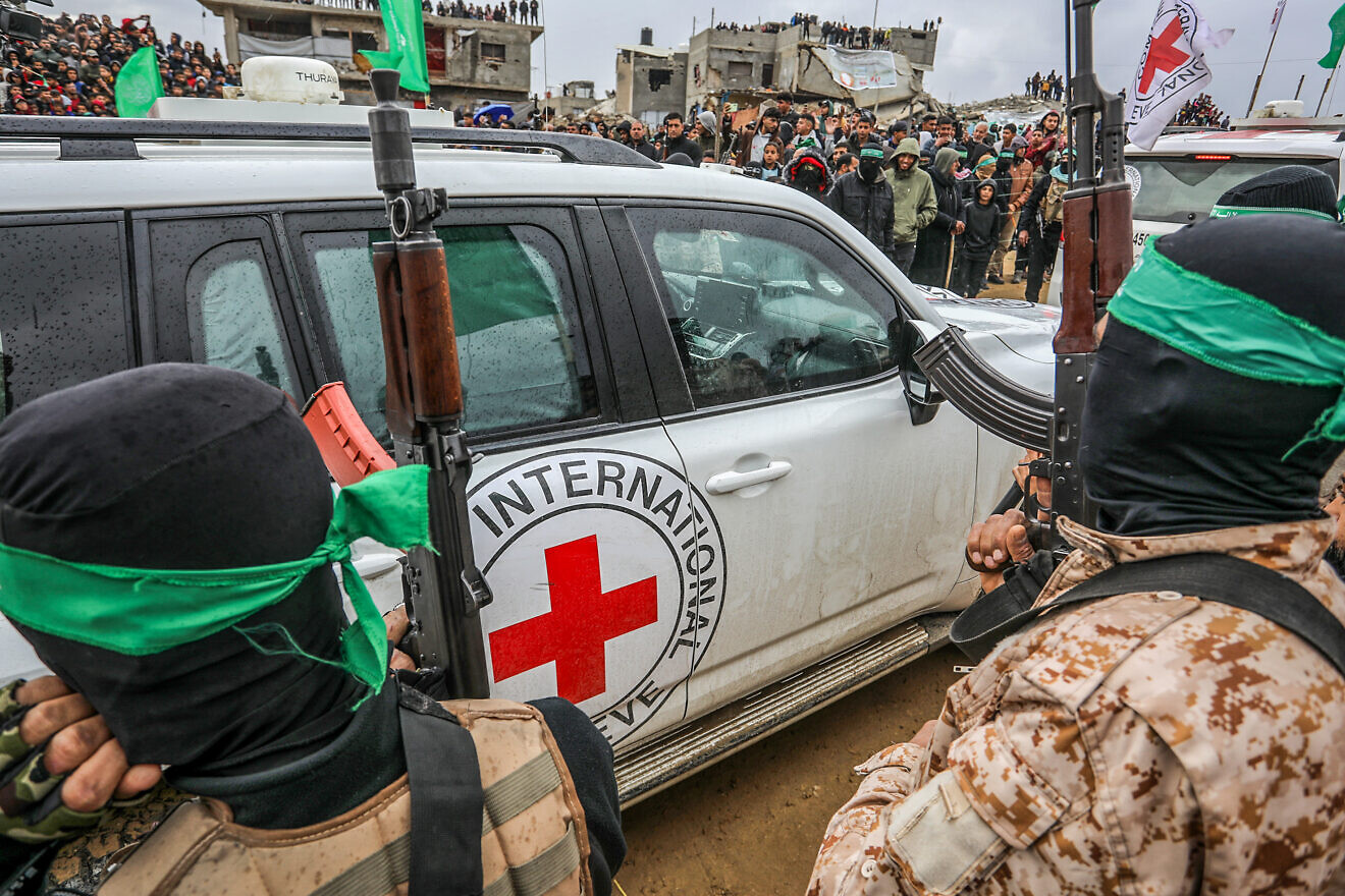 Hamas terrorists next to a Red Cross vehicle amid a transfer of four bodies of Israeli hostages, whom Hamas murdered, to Israel, Gaza, Feb. 20, 2025. Credit: Abed Rahim Khatib/Flash90.