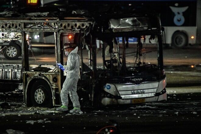 An investigator examines a bombed bus in Bat Yam, south of Tel Aviv, Feb. 20, 2025. Credit: Flash90.